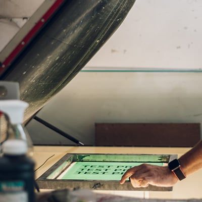 Exposing a silk screen inside a light box.